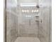 Modern glass shower featuring gray tiling, mosaic accents, shelving, and contemporary fixtures at 620 Nasturtium Ct, Nokomis, FL 34275