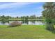 Scenic backyard view of a serene pond and lush landscaping at 6408 Rookery Cir, Bradenton, FL 34203