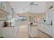 Bright kitchen featuring white cabinets, an island, granite countertops, tile flooring, and views of the lake at 6408 Rookery Cir, Bradenton, FL 34203