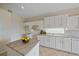 Bright kitchen featuring white cabinets, an island, granite countertops, tile flooring at 6408 Rookery Cir, Bradenton, FL 34203