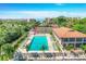Aerial view showcasing the pool, tennis courts, and surrounding buildings at 6415 Midnight Pass Rd # 710, Sarasota, FL 34242