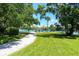 Scenic view of a waterfront community park with benches, green grass, and mature shade trees on a sunny day at 6415 Midnight Pass Rd # 710, Sarasota, FL 34242