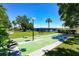 Well-lit shuffleboard court in green space with view of bridge and surrounding greenery under a clear blue sky at 6415 Midnight Pass Rd # 710, Sarasota, FL 34242