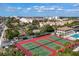 Overhead view of the tennis courts in a well-maintained community with landscaping and surrounding residential buildings at 6415 Midnight Pass Rd # 710, Sarasota, FL 34242