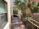 Exterior walkway with metal railing leads to a lush, tropical view with mature palm trees offering shade and architectural interest at 6430 Sun Eagle Ln # 203, Bradenton, FL 34210