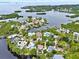 An aerial view showcases waterfront homes, each featuring mature trees, private pools, and easy water access at 748 Soundview Dr, Palm Harbor, FL 34683