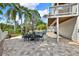 A large brick patio with a dining table, a sparkling pool, and lush landscaping makes it perfect for outdoor entertaining at 748 Soundview Dr, Palm Harbor, FL 34683