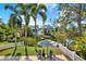 Landscaped backyard with a brick patio, fire pit, lounge chairs, and waterfront views at 748 Soundview Dr, Palm Harbor, FL 34683