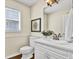 Charming half-bathroom featuring a white vanity with a modern faucet and framed mirror at 748 Soundview Dr, Palm Harbor, FL 34683
