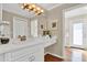 Bathroom featuring a white vanity with gold fixtures, decorative wall art and doorway to the exterior deck at 748 Soundview Dr, Palm Harbor, FL 34683