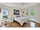 Bright bedroom with hardwood floors, ceiling fan, balcony access, and stylish decor at 748 Soundview Dr, Palm Harbor, FL 34683