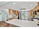 Bright kitchen with a center island, light wood cabinets, stainless steel appliances, and balcony access at 748 Soundview Dr, Palm Harbor, FL 34683