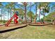 Colorful playground with slides and climbing structures surrounded by lush trees and well-maintained landscaping at 748 Soundview Dr, Palm Harbor, FL 34683