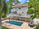 Beautiful backyard pool with a brick paver deck, outdoor dining area, and lush green landscaping at 748 Soundview Dr, Palm Harbor, FL 34683