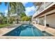 A refreshing private pool surrounded by a brick patio, white fence, and beautiful landscaping offers the perfect outdoor retreat at 748 Soundview Dr, Palm Harbor, FL 34683