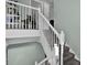 Well-lit staircase featuring carpeted steps and white railings, leading to upper levels with style and safety at 748 Soundview Dr, Palm Harbor, FL 34683