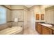 Luxurious bathroom with a soaking tub, marble countertops, vanity, and ceramic tile accents at 8016 Bounty Ln, Bradenton, FL 34202