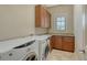 Well-lit laundry room featuring granite countertops, ample cabinet space, and modern washer and dryer units at 8016 Bounty Ln, Bradenton, FL 34202