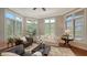 Bright living room featuring hardwood floors, a ceiling fan, and large windows at 8016 Bounty Ln, Bradenton, FL 34202