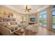 Bright living room with coffered ceiling, large windows, comfortable seating, and access to a pool at 8016 Bounty Ln, Bradenton, FL 34202