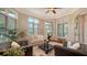 Spacious living room features hardwood floors, a ceiling fan, and large windows at 8016 Bounty Ln, Bradenton, FL 34202
