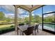 Covered outdoor dining area with a view of the pool, the lake, and well manicured landscaping at 8016 Bounty Ln, Bradenton, FL 34202