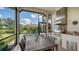 Covered outdoor kitchen features stainless steel appliances, a grill, and a dining area with lush landscaping at 8016 Bounty Ln, Bradenton, FL 34202