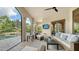 Inviting outdoor living area with comfortable seating, ceiling fan, and scenic views of the pool and lush landscaping at 8016 Bounty Ln, Bradenton, FL 34202