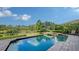Sparkling pool and spa surrounded by lush landscaping and serene lake views create a tranquil outdoor oasis at 8016 Bounty Ln, Bradenton, FL 34202