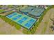 Aerial view of tennis and pickleball courts surrounded by lush landscaping in a gated community at 8016 Bounty Ln, Bradenton, FL 34202
