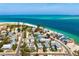 An aerial view of a home in a beachfront community with turquoise waters and pristine sandy shores at 802 N Bay Blvd, Anna Maria, FL 34216