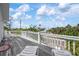 Relaxing outdoor balcony with seating and neighborhood views of blue skies and palm trees at 802 N Bay Blvd, Anna Maria, FL 34216