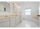 Bright bathroom with double sink vanity, large mirror and soaking tub with window at 802 N Bay Blvd, Anna Maria, FL 34216