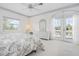 Bright bedroom featuring a large bed, dresser, and French doors to a balcony at 802 N Bay Blvd, Anna Maria, FL 34216