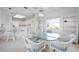 Bright dining area with glass table, wicker chairs, and open floor plan to kitchen at 802 N Bay Blvd, Anna Maria, FL 34216