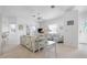 Bright living room with white wicker furniture, ceiling fan and access to a balcony and the entry door at 802 N Bay Blvd, Anna Maria, FL 34216