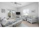 Bright, airy living room with wicker furniture and a glass coffee table, leading to a sunny outdoor space at 802 N Bay Blvd, Anna Maria, FL 34216