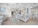 Cozy living room featuring white wicker furniture, ceiling fan, and a view of the kitchen at 802 N Bay Blvd, Anna Maria, FL 34216