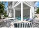 Inviting covered pool area with lounge chairs and outdoor dining space at 802 N Bay Blvd, Anna Maria, FL 34216