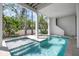 Private backyard pool area with lush greenery, covered patio, and steps leading to the house at 802 N Bay Blvd, Anna Maria, FL 34216
