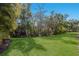 Spacious backyard featuring lush grass and mature trees at 8073 Tybee Ct, University Park, FL 34201