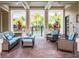 Comfortable outdoor lounge area with brick floors, ceiling fans, plush seating, and a view of the community pool at 8073 Tybee Ct, University Park, FL 34201