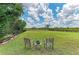 Large backyard with well manicured lawn, simple seating arrangement, and iron fence at 8103 Snowy Egret Pl, Bradenton, FL 34202