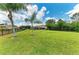 Expansive backyard featuring lush green grass, a screen-enclosed pool, mature trees, and a secure fence at 8103 Snowy Egret Pl, Bradenton, FL 34202