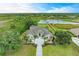 Aerial view of an estate home featuring a long driveway, manicured lawn, and lush landscaping around the property at 8103 Snowy Egret Pl, Bradenton, FL 34202