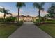 Elegant home featuring a long driveway, well-manicured lawn, and mature landscaping with palm trees at 8103 Snowy Egret Pl, Bradenton, FL 34202