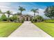A stunning single-Gathering home featuring a well-manicured lawn and mature palm trees at 8103 Snowy Egret Pl, Bradenton, FL 34202