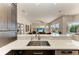 Modern kitchen with stainless steel sink, quartz countertops, sleek dark cabinets, and an open view of the living area at 8103 Snowy Egret Pl, Bradenton, FL 34202