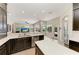 Bright kitchen features stainless steel appliances, dark cabinetry, and a seamless transition to the outdoor pool area at 8103 Snowy Egret Pl, Bradenton, FL 34202