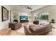 Inviting living room with comfortable leather seating, a large TV, and views of the outdoor pool area at 8103 Snowy Egret Pl, Bradenton, FL 34202